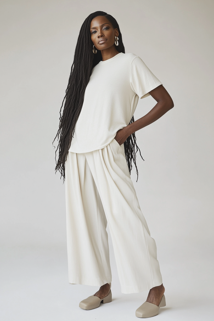 Model wearing The Clio Scoop in warm ivory cotton jersey with a relaxed fit and scoop neck.